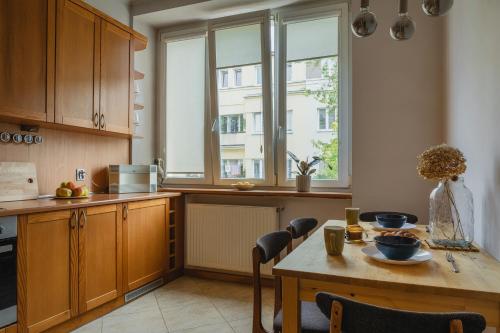 a kitchen with a wooden table and a window at Warsaw Concierge Racławicka in Warsaw