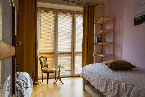 a bedroom with a bed and a chair and a window at Warsaw Concierge Racławicka in Warsaw
