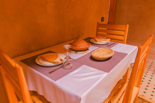 a table with a white table cloth and plates on it at Kasbah Roseville in Ait Sedrate Sahl Gharbia
