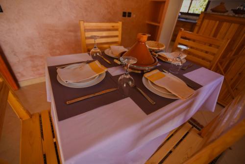 a table with a white table cloth and a tea kettle at Kasbah Roseville in Ait Sedrate Sahl Gharbia