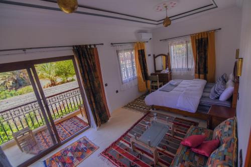 ein Schlafzimmer mit einem Bett und einem Balkon in der Unterkunft Kasbah Roseville in Aït Ouahi