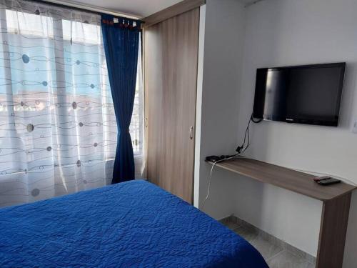 1 dormitorio con 1 cama, TV y ventana en Acogedor apartamento La Nubia, en Manizales