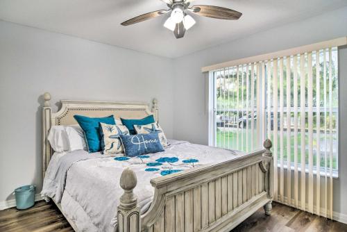 a bedroom with a bed with blue pillows and a ceiling fan at St Pete Bungalow Less Than 2 Mi to Beach and Downtown! in St Petersburg