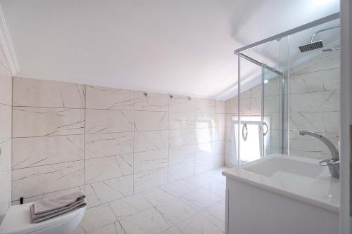 a white bathroom with a sink and a toilet at Villa Erya 2 in Fethiye