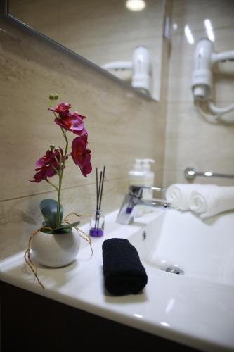 une fleur dans un vase sur un lavabo dans l'établissement Quinta Vale de Palheiros, à Santa Comba Dão