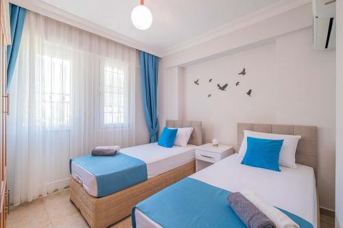 two beds in a room with blue and white at Villa Erya 2 in Fethiye