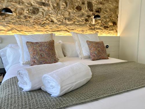 a bed with white sheets and pillows on it at The Tailor's Garden in Santiago de Compostela