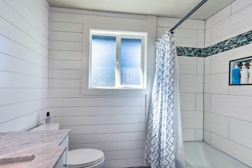 a white bathroom with a toilet and a window at Lakeside Lacey Gem with Sauna and Private Dock in Lacey