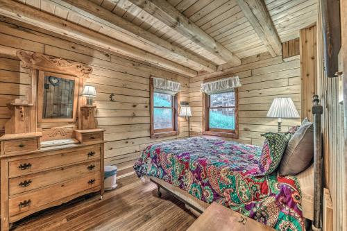 1 dormitorio con 1 cama en una cabaña de madera en Tree-Lined Pollys Perch with Mountain Views!, en Ruidoso