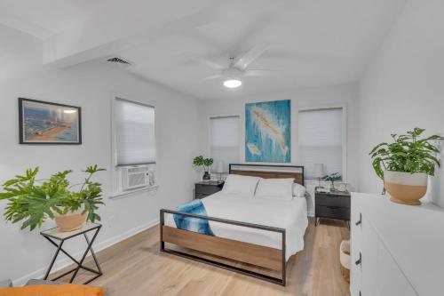 a bedroom with a bed and two potted plants at Spacious 3-Bedroom Bungalow in Bradley Beach in Bradley Beach