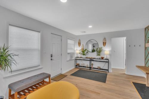 a living room with white walls and a yellow chair at Spacious 3-Bedroom Bungalow in Bradley Beach in Bradley Beach