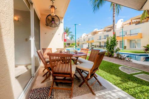 a patio with a table and chairs and a pool at Relaxing Village, Acapulco Diamante, Rooftop in Acapulco