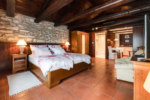 a bedroom with a bed and a stone wall at Apartments Stancija 1904 - Adults only in Svetvinčenat