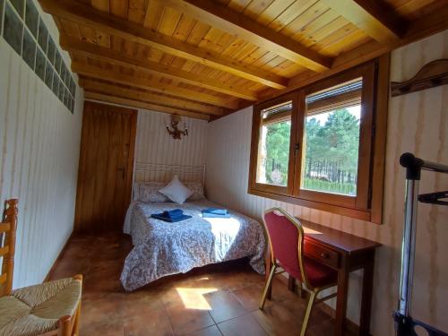 1 dormitorio con cama, escritorio y ventana en Casa Esmeralda en ZAFIRO LAGUNAZO Parque Natural Rio Mundo Riopar, en Riópar