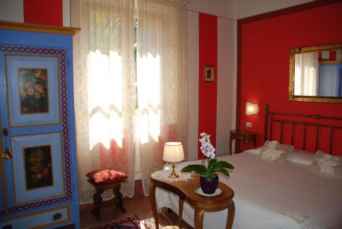 a bedroom with red walls and a bed and a window at Il Rondò Boutique Hotel in Montepulciano
