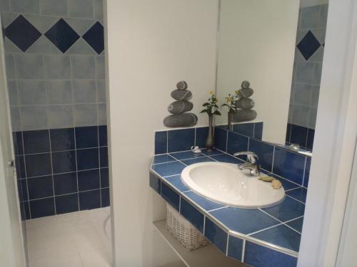 ein blau gefliestes Bad mit einem Waschbecken und einer Dusche in der Unterkunft Rose Niche in Cavalaire-sur-Mer