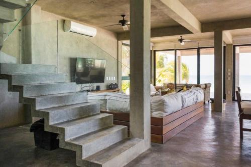 a house with a staircase in a room with a bed at Casa Gonza Holbox in Holbox Island