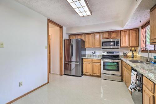 a kitchen with wooden cabinets and stainless steel appliances at Bryan Home with Deck and Yard about 4 Mi to Texas A and M! in Bryan