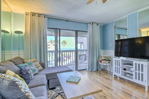 a living room with a couch and a flat screen tv at Beachside Corpus Christi Condo with Amenities! in Corpus Christi