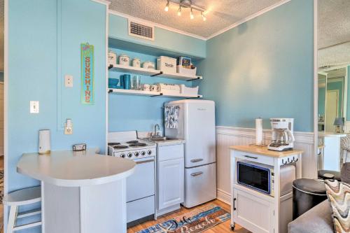 a kitchen with white appliances and a blue wall at Beachside Corpus Christi Condo with Amenities! in Corpus Christi