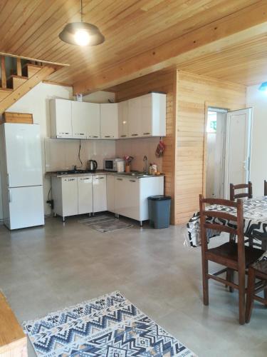 a kitchen with white appliances and a wooden ceiling at Little house Katia Mestia in Mestia
