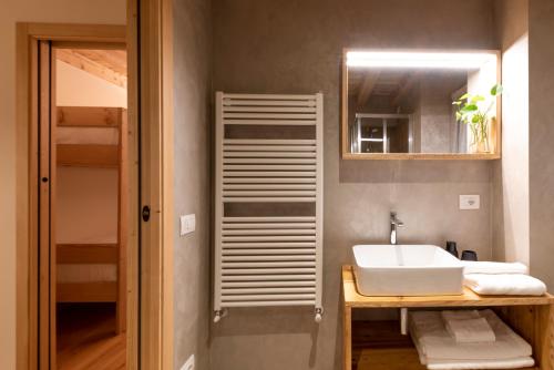 een badkamer met een wastafel en een spiegel bij Foresteria Spluga in Campodolcino