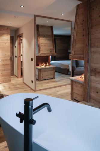 a bathroom with a bath tub and a fireplace at Sci Sport rooms & suites in Bormio