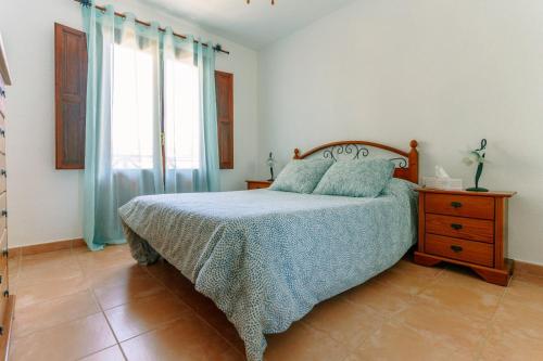 a bedroom with a bed and a dresser and a window at Starfish playa in Los Cancajos
