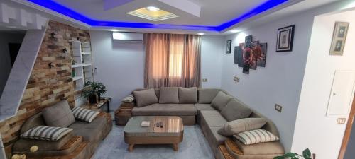 a living room with a couch and a table at L'Andalousia "10 minutes from airport" in Ariana
