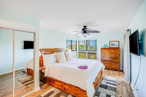 a bedroom with a large bed and a mirror at Kauai Beach Villas E5 in Lihue