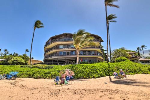 a building with palm trees and people on the beach at Gorgeous Oceanfront Kihei Condo with Balcony! in Wailea