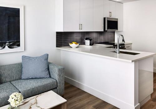 a kitchen with a counter and a chair and a sink at AKA West Palm in West Palm Beach