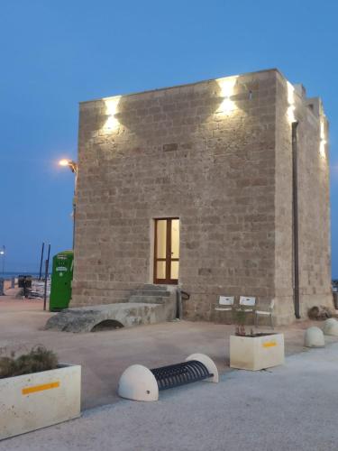 a brick building with a black and white object in front of it at Casa Gialla in Torre Pali 