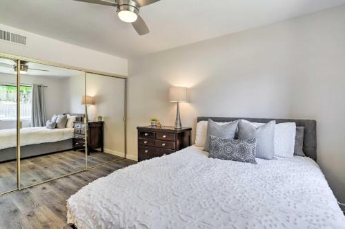 a bedroom with a white bed and a mirror at Furnished Patio and Mtn View Palm Desert Retreat in Palm Desert