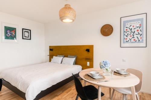 um quarto com uma cama e uma pequena mesa em Urban Condo em Liepāja