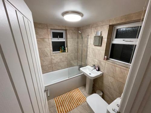 a bathroom with a sink and a tub and a toilet at Cathedral view Cottage in Gloucester