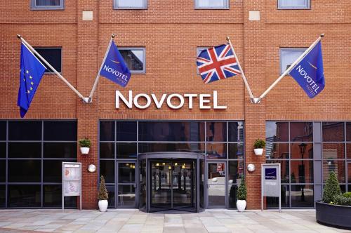 a no needed sign on a brick building with flags at Novotel Manchester Centre in Manchester