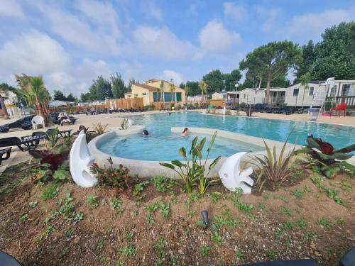 a swimming pool at a resort with people in it at Les sables du midi in Valras-Plage