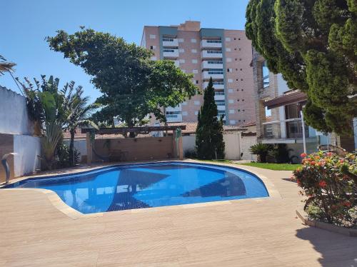 uma piscina azul num quintal com um edifício em Pousada & Hostel Boca da Barra em Itanhaém