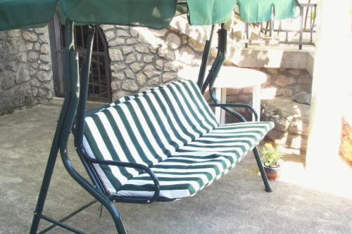 a green and white chair sitting under an umbrella at Apartments with WiFi Opric, Opatija - 7756 in Lovran