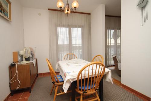 Apartments with a parking space Pula - 7681 في بولا: غرفة طعام مع طاولة وأربعة كراسي
