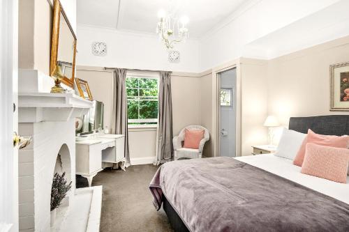 a bedroom with a bed and a fireplace at The Bundanoon Guest House in Bundanoon