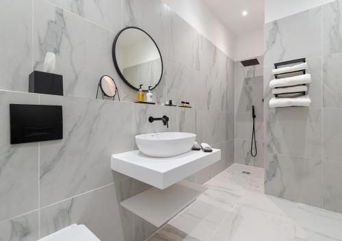 a white bathroom with a sink and a mirror at Luxury Georgian City Retreat With Hot Tub & Patio in Edinburgh