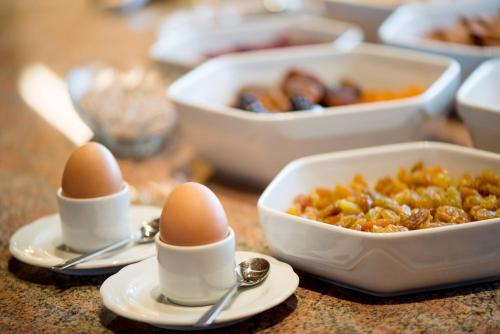 a table topped with eggs and bowls of food at Hotel Garni Doris in Castelrotto