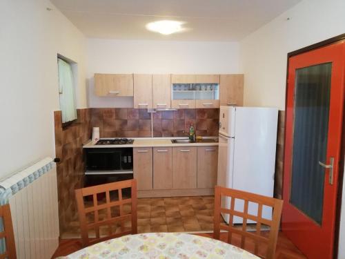 a kitchen with a white refrigerator and a table and chairs at Apartments with a parking space Opric, Opatija - 7726 in Opric