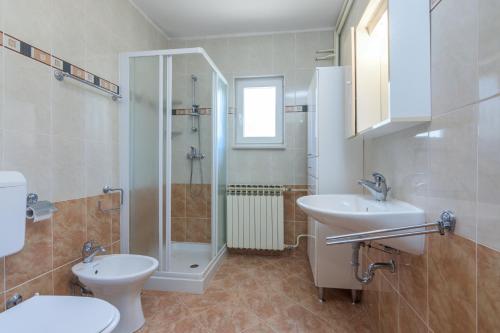 W łazience znajduje się prysznic, toaleta i umywalka. w obiekcie Family friendly house with a parking space Sveti Martin, Central Istria - Sredisnja Istra - 7849 w mieście Ružići