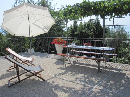 a table and a bench and an umbrella at Apartments with a parking space Medveja, Opatija - 7721 in Medveja