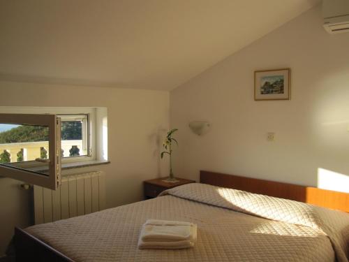 a bedroom with a bed and a window at Apartments with a parking space Medveja, Opatija - 7721 in Medveja