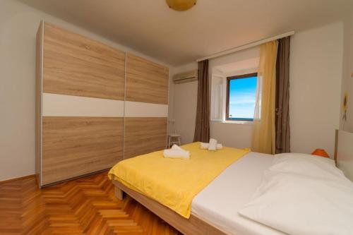 Apartments by the sea Nerezine, Losinj - 7963 في نيرازين: غرفة نوم بسرير كبير ونافذة