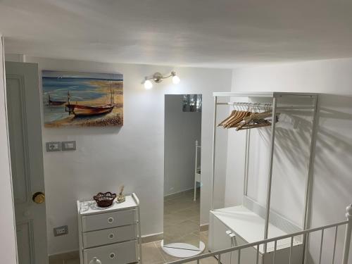 a room with a cabinet and a painting of a boat at L&L House in Catania